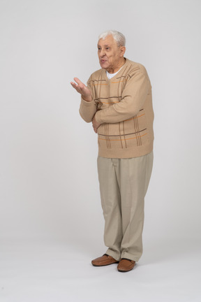 Vista frontal de un anciano con ropa informal explicando algo