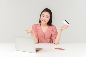 Lächelnde junge asiatische frau, die das on-line-einkaufen tut