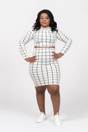 Front view of a beautiful young lady standing with hands on hips