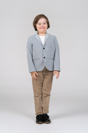 A young boy in a gray jacket and brown pants