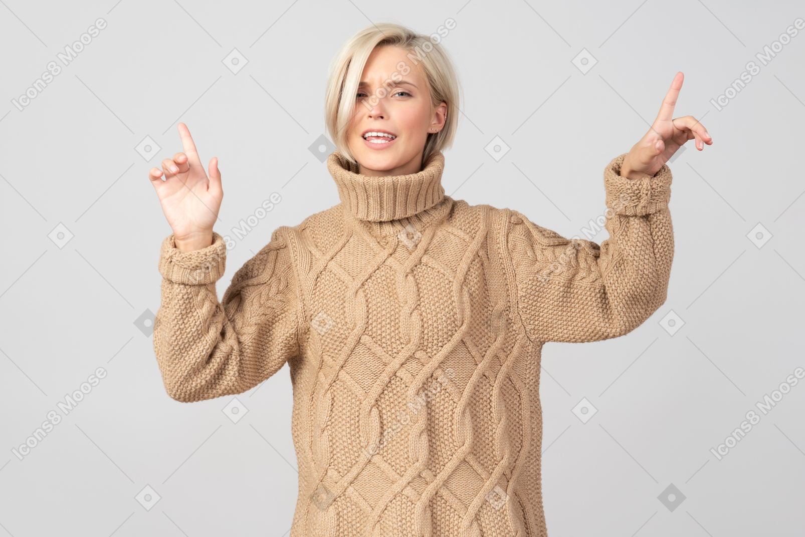 Mujer joven en suéter apuntando hacia arriba.