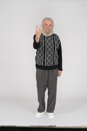 Anciano mostrando gesto con dos dedos