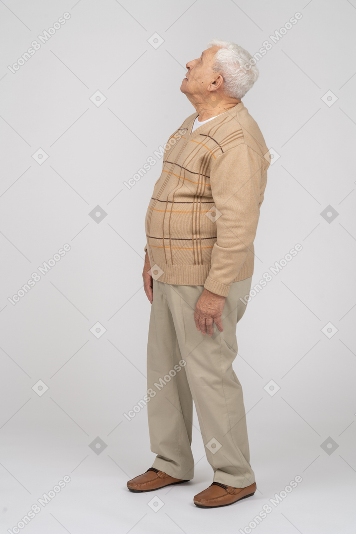 Side view of an impressed ol man in casual clothes looking up