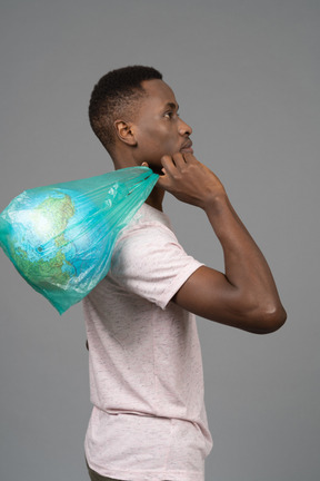 A young man holding a white plastic with the earth globe