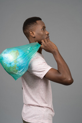 Un joven sosteniendo un plástico blanco con el globo terráqueo