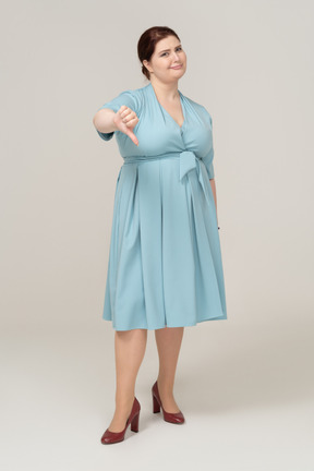 Vista frontale di una donna in abito blu che mostra il pollice verso il basso