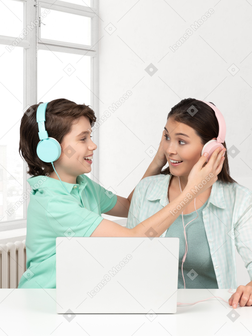Boy putting headphones on a woman's head