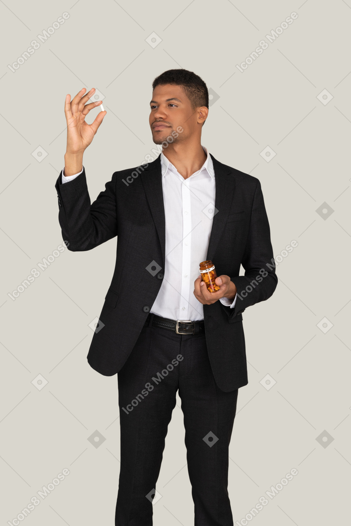 African american man in black suit holding at pills he's holding