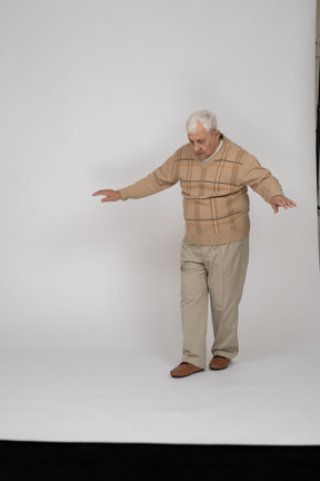 一位穿着休闲服的老人向前走的正面图