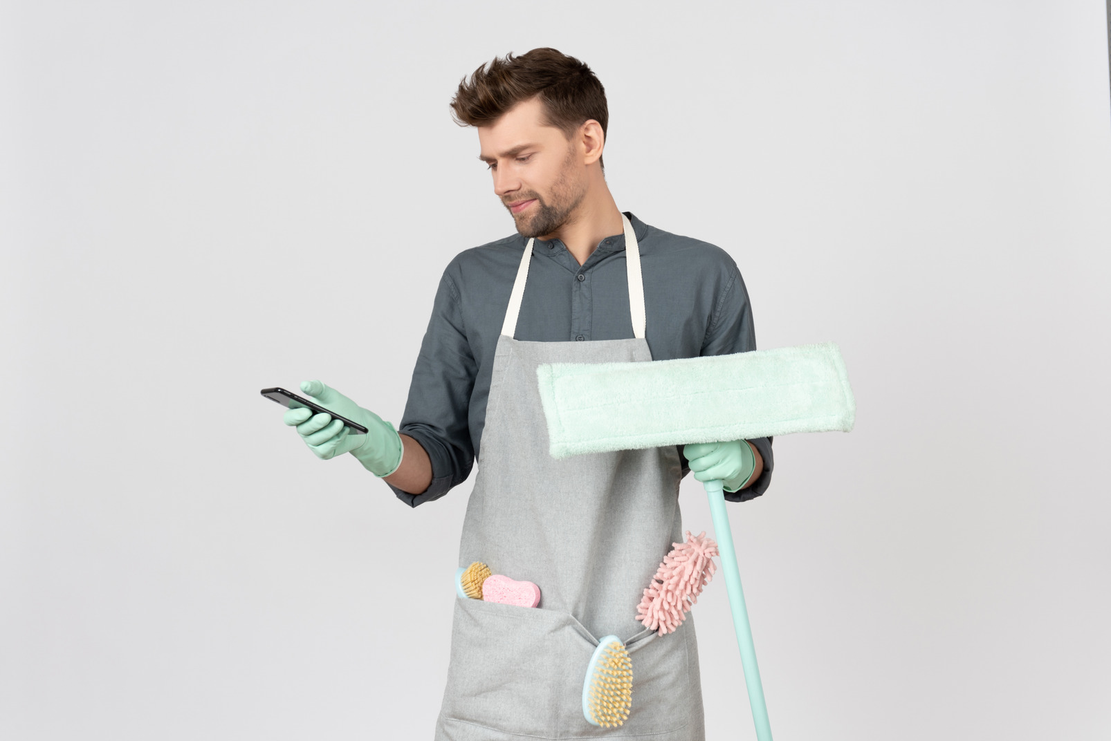 Young househusband holding mop and telephone
