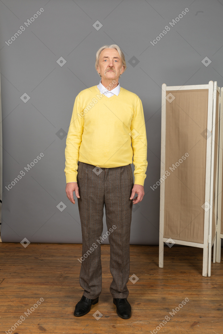 Vista frontal de um homem idoso sem emoção, olhando para a câmera