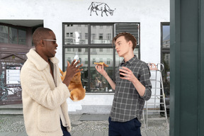 A man standing next to another man holding food