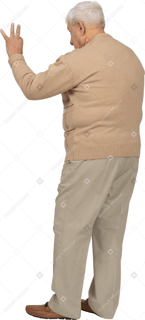 Vista lateral de un anciano con ropa informal que muestra el signo de ok