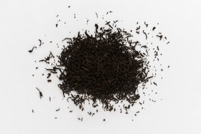 Foglie di tè nero su sfondo bianco