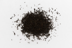 Black tea leaves on white background