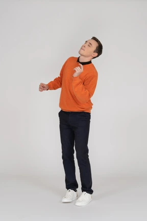 Young man in orange sweatshirt posing