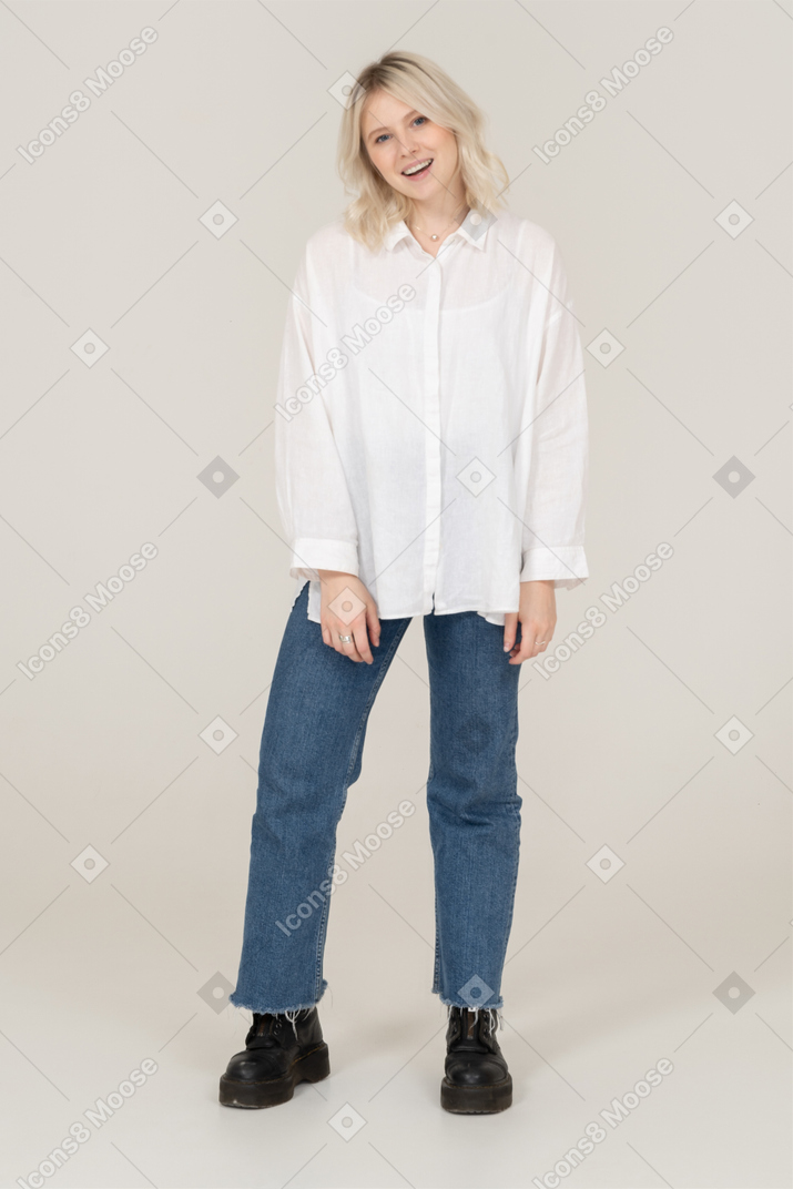 Front view of a blonde female in casual clothes posing and looking at camera
