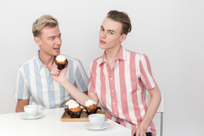 Guy proposing his partner to eat a cupcake