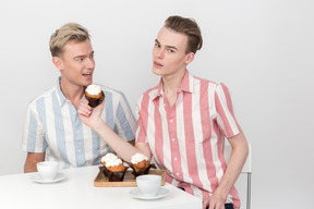 Mec propose à son partenaire de manger un petit gâteau