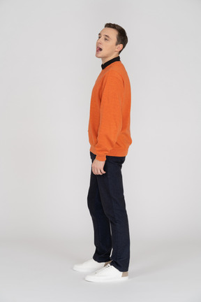 A man in an orange sweater and black pants