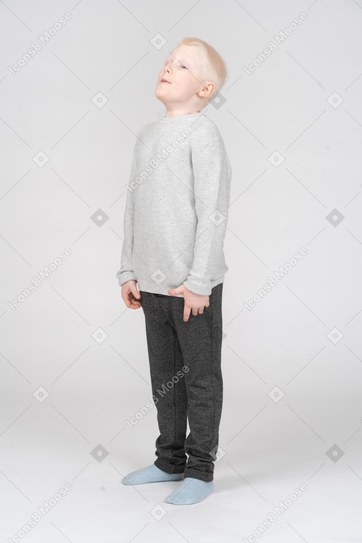 Little boy raising head and whistling