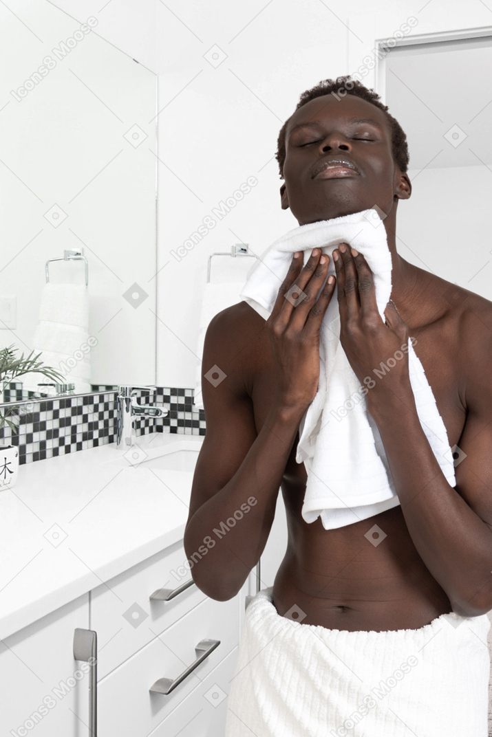 A man drying himself with a towel in a bathroom