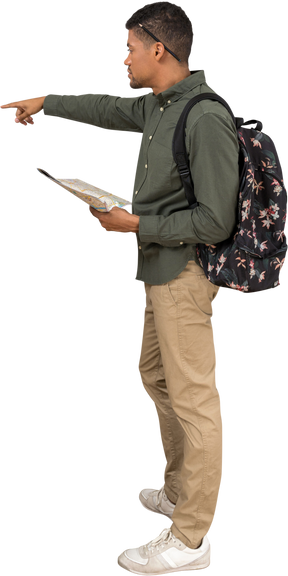 Vista lateral de un hombre con una mochila mirando un mapa y señalando a un lado