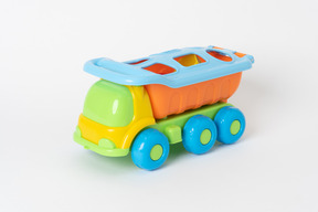 A colorful toy dump truck standing against a plain white background