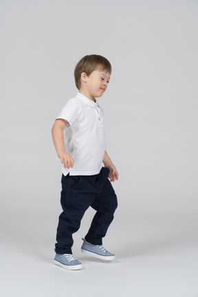 Side view of a little boy taking a step