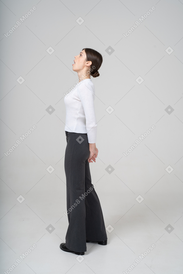 Vista lateral de una mujer mirando hacia arriba con la boca abierta