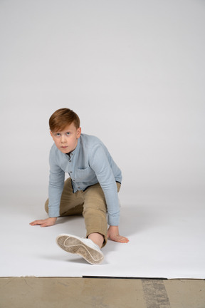 Vista frontal de un niño con camisa azul haciendo una división