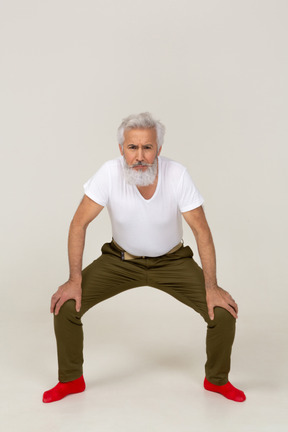 Front view of a frowning man doing a stance