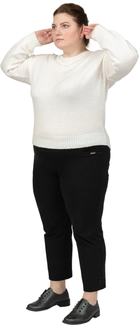Plump woman in casual clothes touching ears