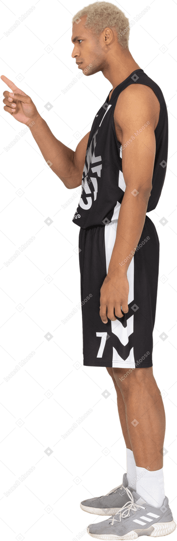 Seitenansicht eines jungen männlichen basketballspielers, der mit dem finger zeigt