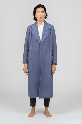 Vista frontal de una mujer con el ceño fruncido y un abrigo azul