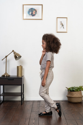 Good looking girl kid posing on the apartment background