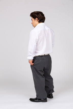 Man in office clothes standing with his back to camera