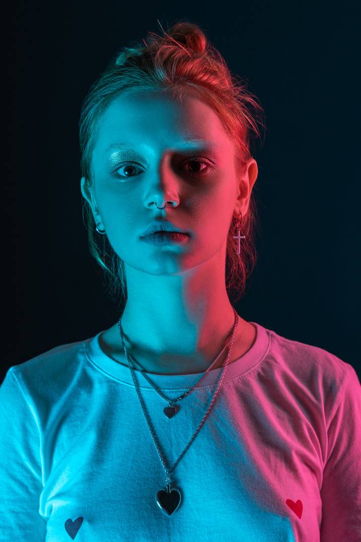 Close-up straight portrait of young female model in blue light