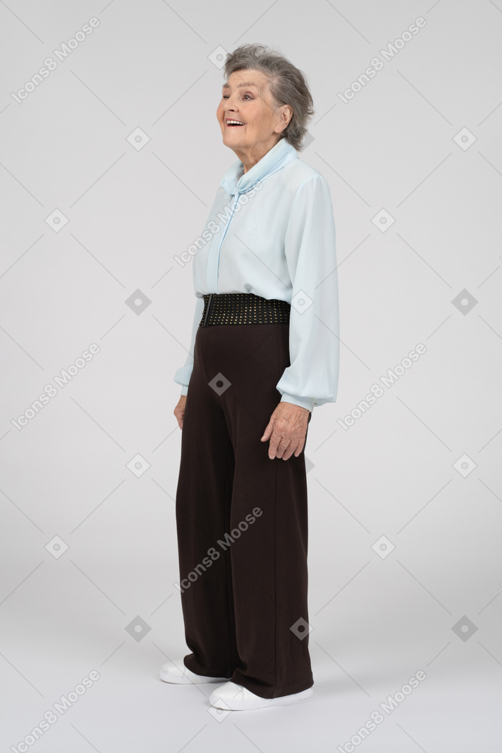 Вид в три четверти на пожилую женщину, улыбающуюся и подмигивающую правым глазом