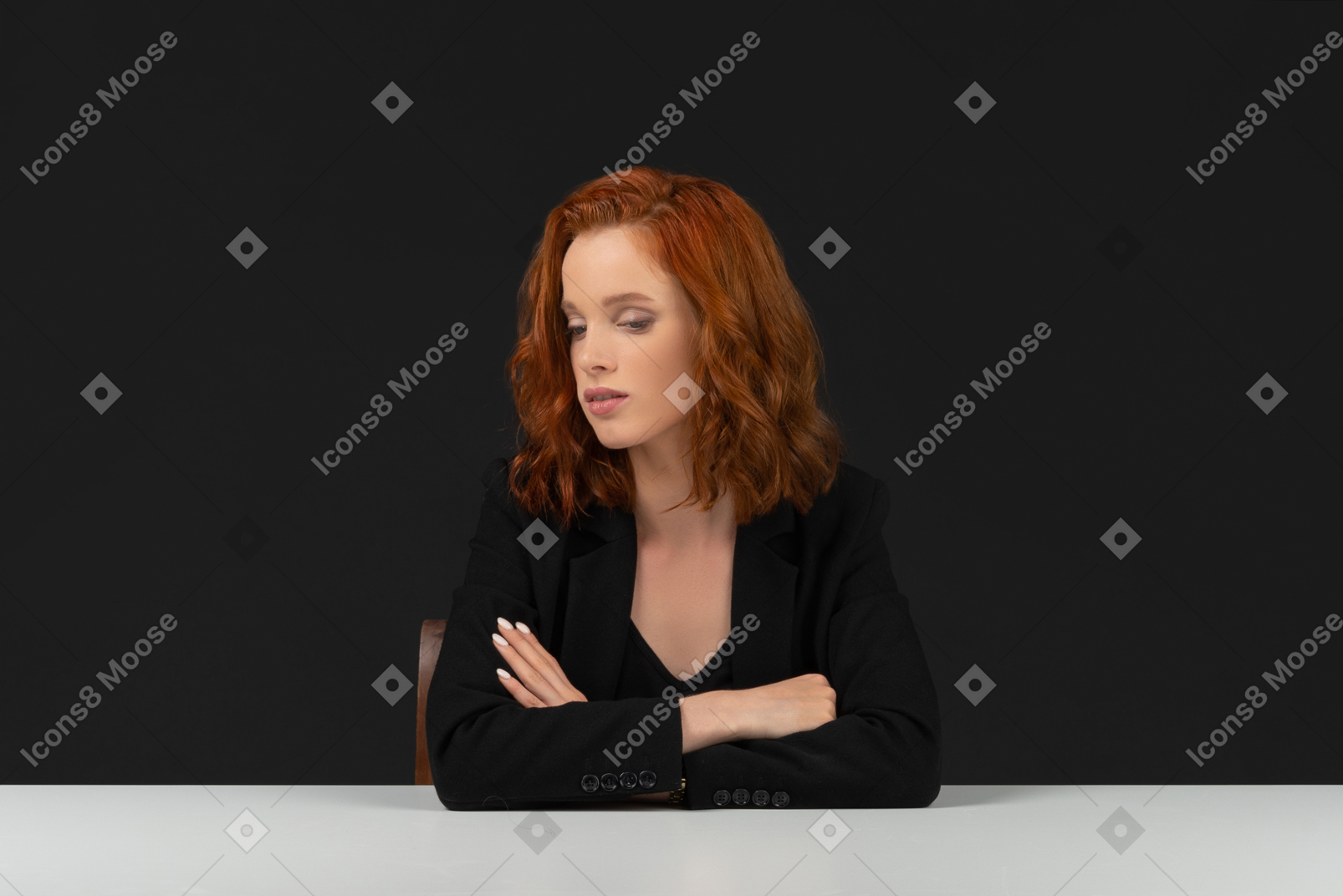 A frontal view of the pretty young woman sitting at the table with closed eyes