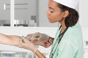 A female doctor is giving injection on patient's arm