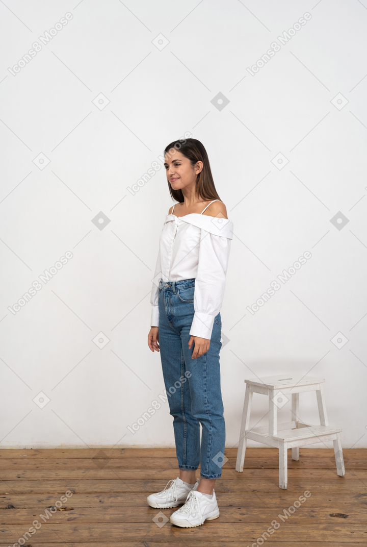 Woman in white shirt and blue jeans standing
