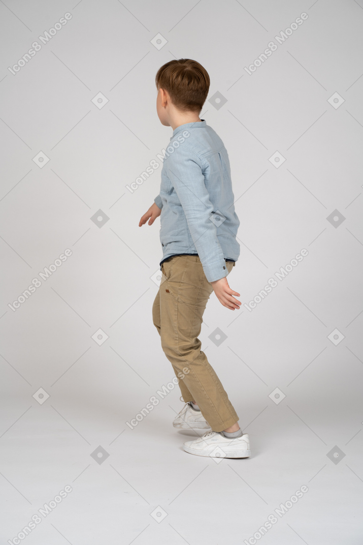 Back view of a young boy walking away