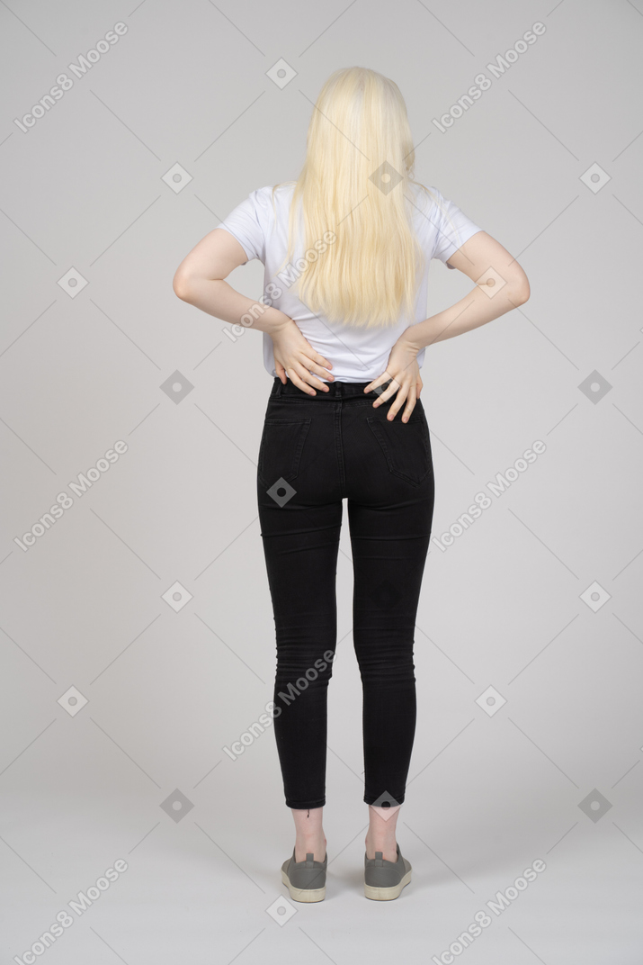 Vista trasera de una mujer de pelo largo estirando la espalda