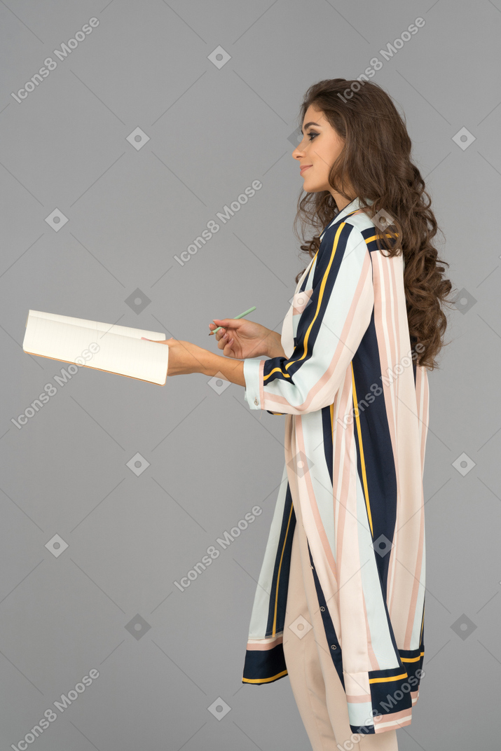 Cheerful arab woman holding a notebook