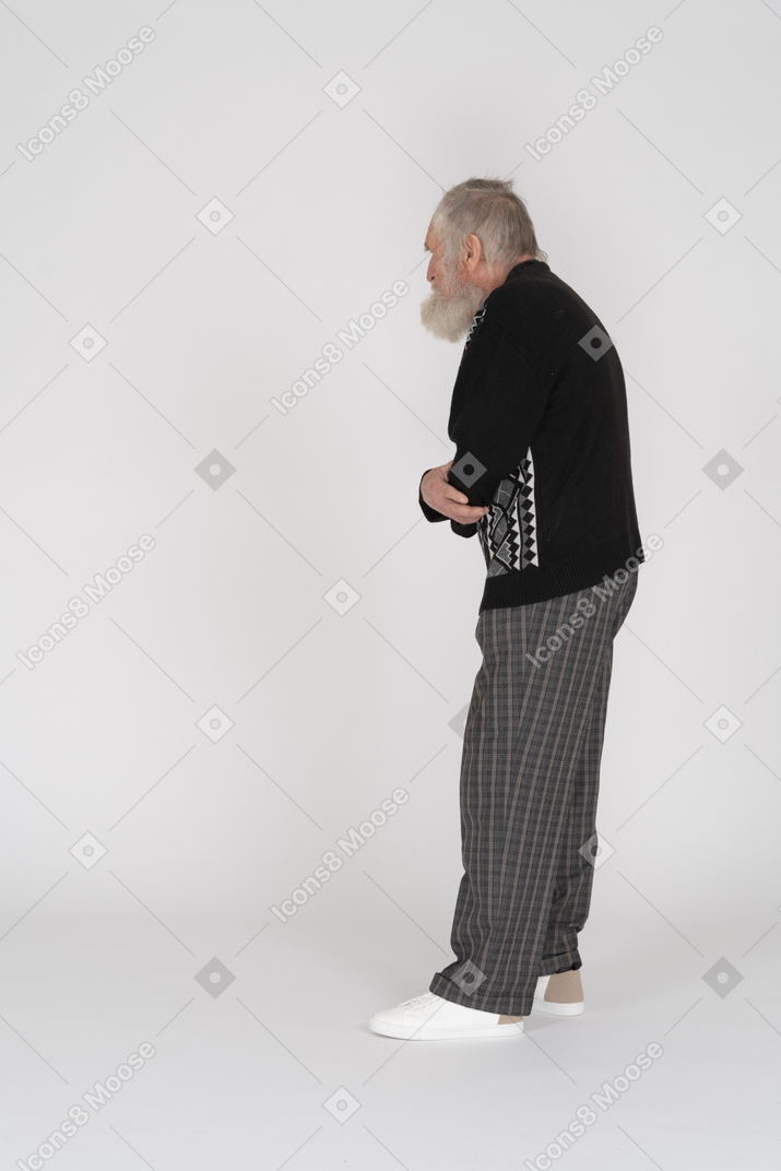 Vista laterale di un uomo anziano con le braccia conserte