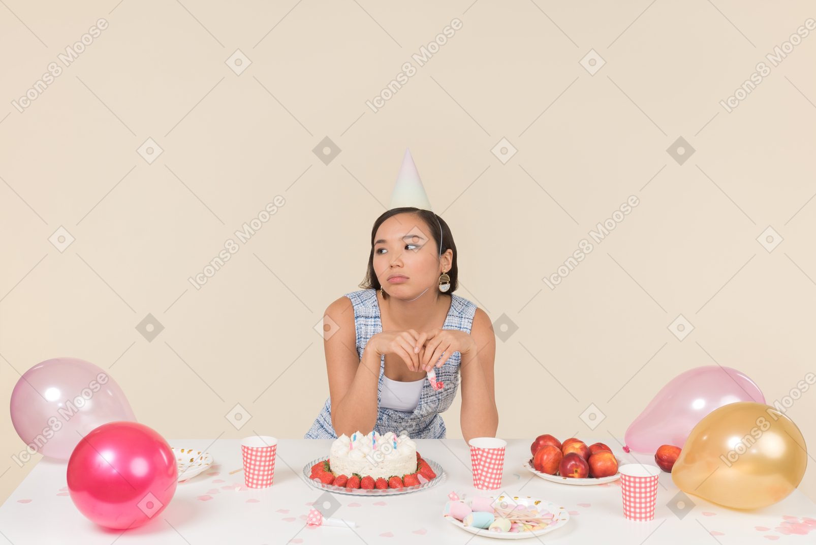 Triste busca joven asiática sentada en la mesa de cumpleaños