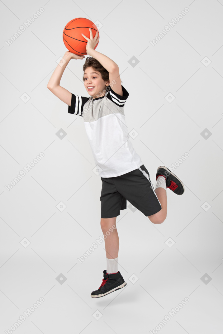Boy moving and throwing a basketball ball up