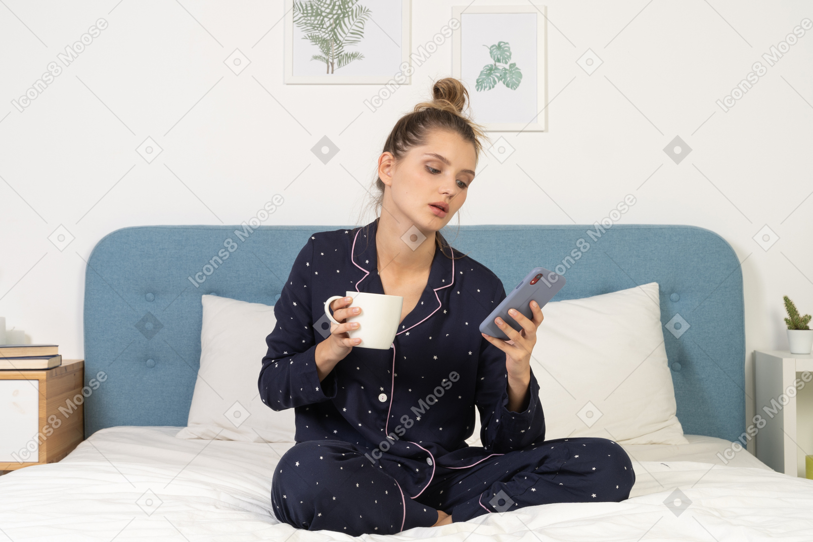 Frente a una mujer joven en pijama sentada en la cama con la taza de café mientras revisa instagram