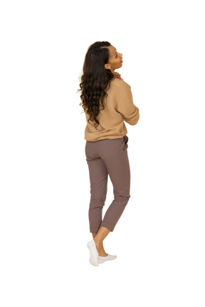 Three-quarter back view of a dark-skinned pleased young female holding hands together